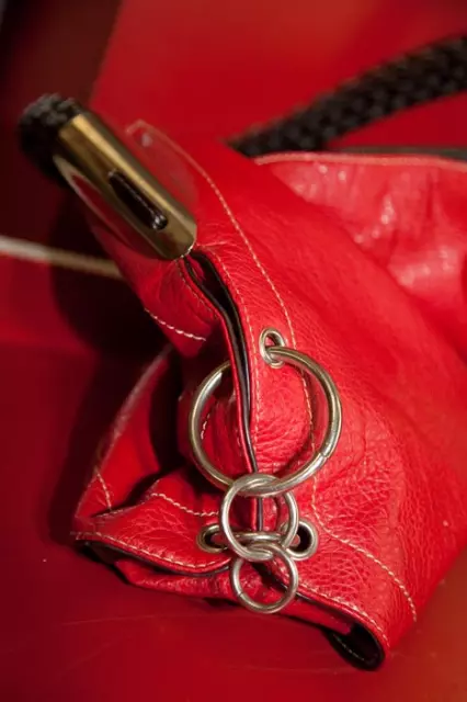 rote Lacktasche mit Metallringen als Accessoire